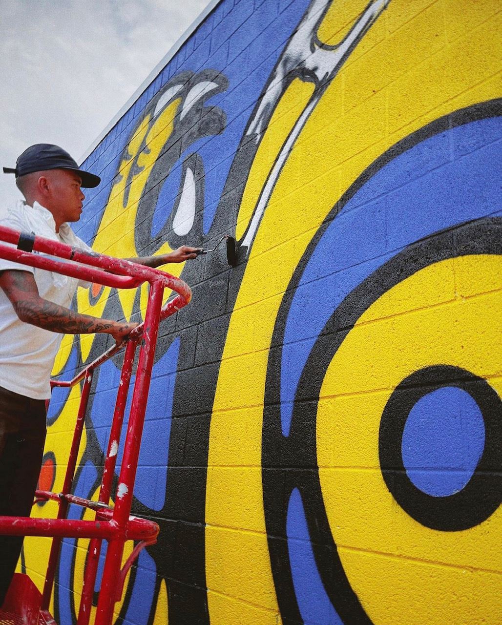 Artist painting AAPI Month mural at George Elder Park